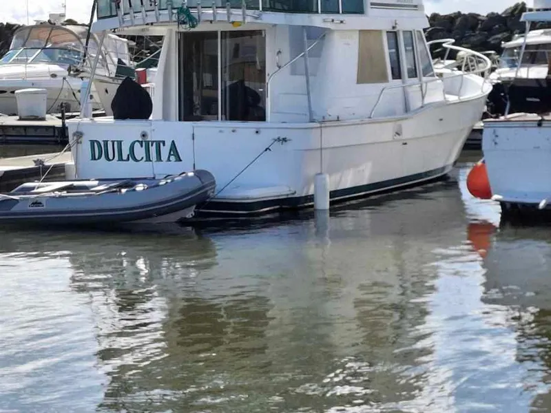 Slide: The Image of 1997 Mainship 350 yacht "Dulcita" docked with inflatable boat nearby. - 24