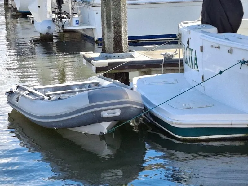 Slide: The Image of Inflatable dinghy moored to a 1997 Mainship 350 yacht at a marina. - 25