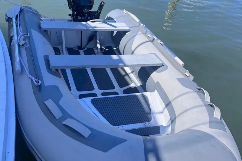 Slide: The Image of Inflatable boat docked on water, featuring a motor and seating. - 28