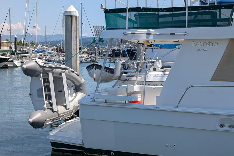 Slide: The Image of 1997 Mainship 350 yacht docked in marina with inflatable boat attached. - 34