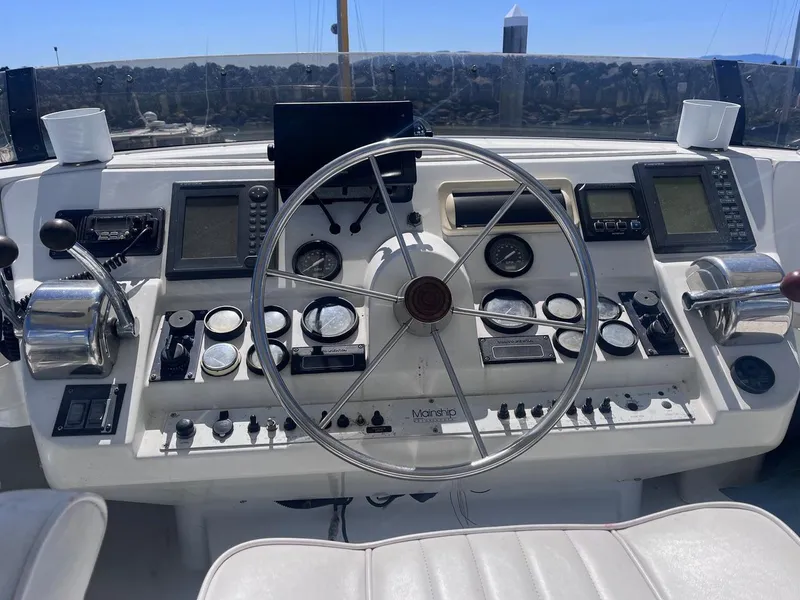 Slide: The Image of 1997 Mainship 350 helm with steering wheel, gauges, and navigation equipment. - 6