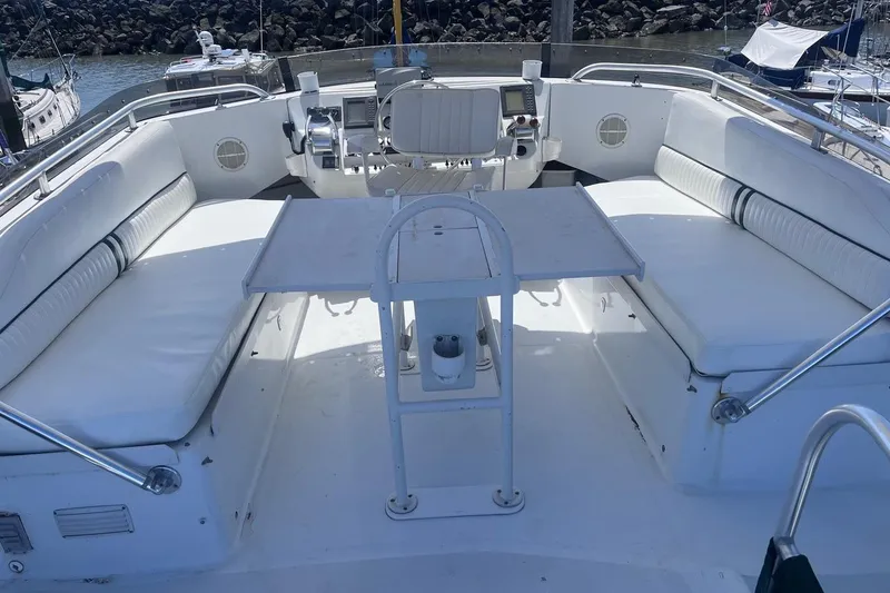 Slide: The Image of 1997 Mainship 350 boat deck with white seating and table, docked at marina. - 9