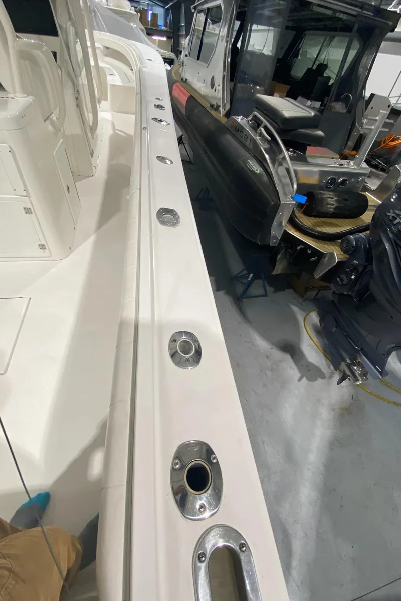 Slide: The Image of 2015 Regulator 34 Center Console boat interior with rod holders, in a workshop setting. - 17