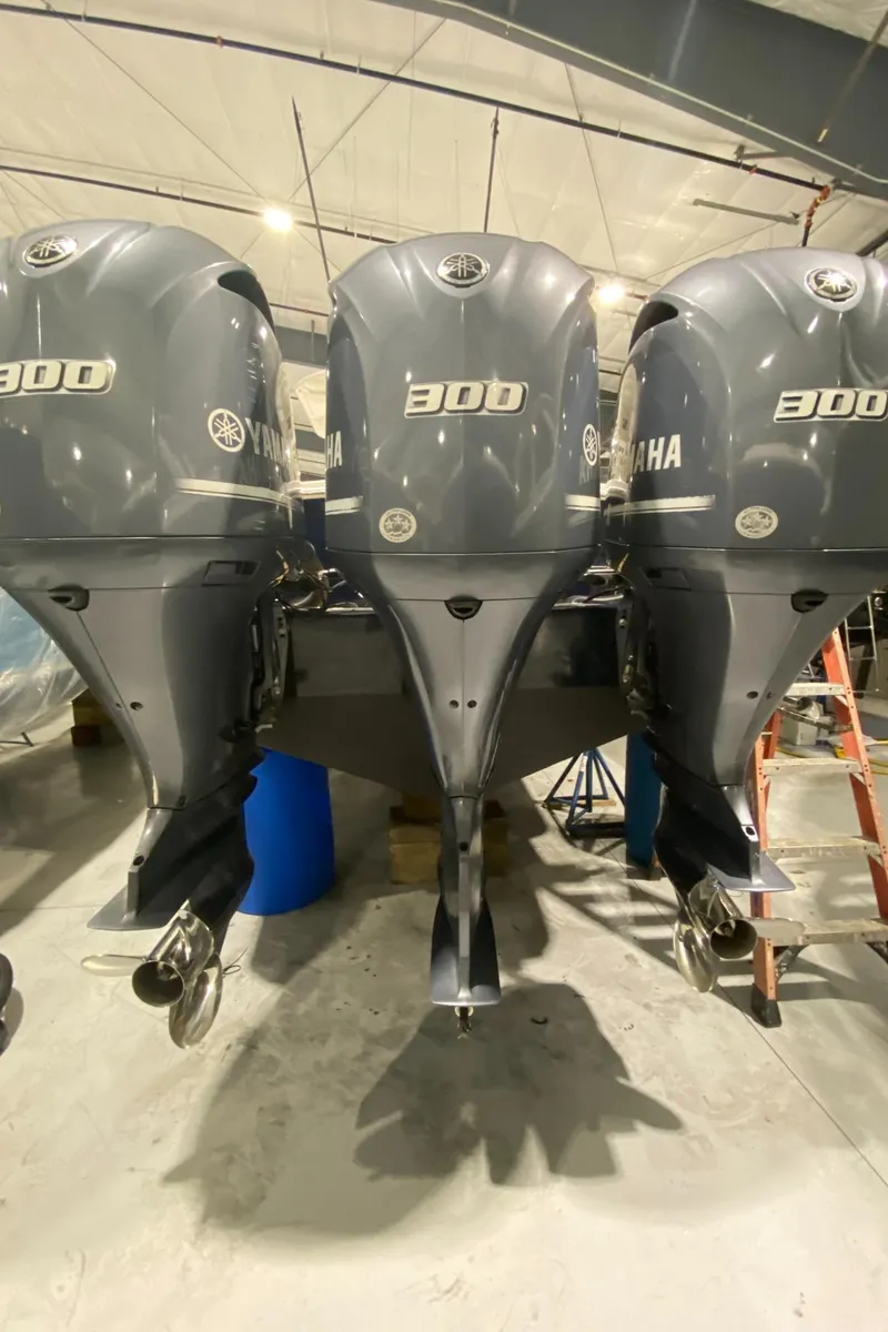 Slide: The Image of 2015 Regulator 34 Center Console with triple Yamaha 300 engines in a garage. - 29