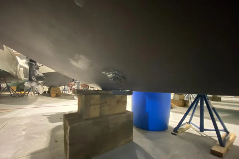 Slide: The Image of 2015 Regulator 34 Center Console boat hull on blocks in a workshop. - 41