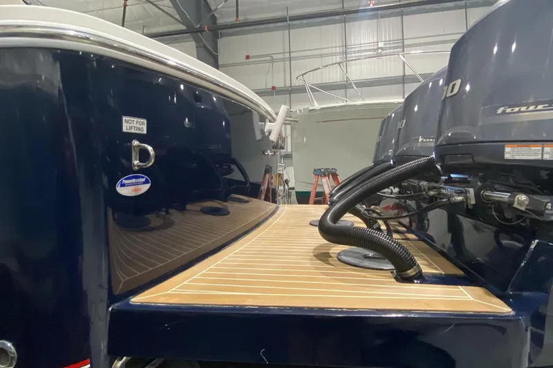 Slide: The Image of 2015 Regulator 34 Center Console boat with twin outboard engines in a storage facility. - 43