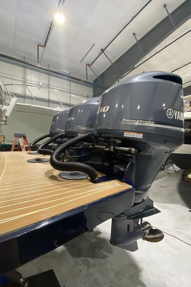 Slide: The Image of 2015 Regulator 34 Center Console with triple Yamaha outboard engines in a showroom. - 44