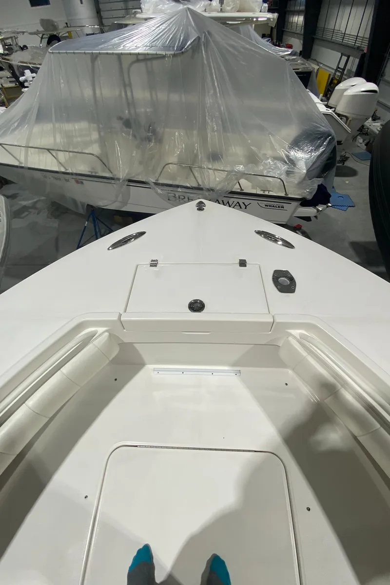 Slide: The Image of 2015 Regulator 34 Center Console boat in storage, with another boat covered in plastic. - 7