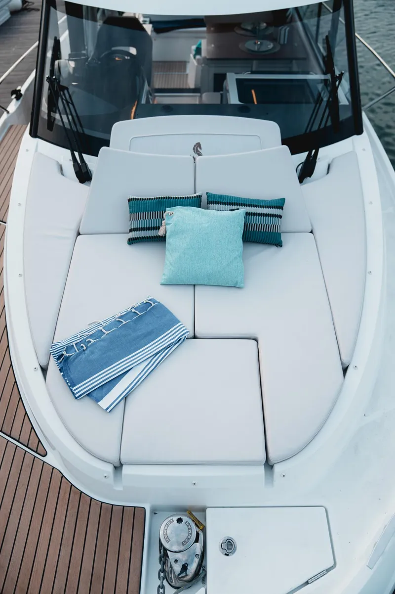 Slide: The Image of 2025 Beneteau Antares 9 boat deck with cushions and towels, showcasing luxury and comfort. - 10