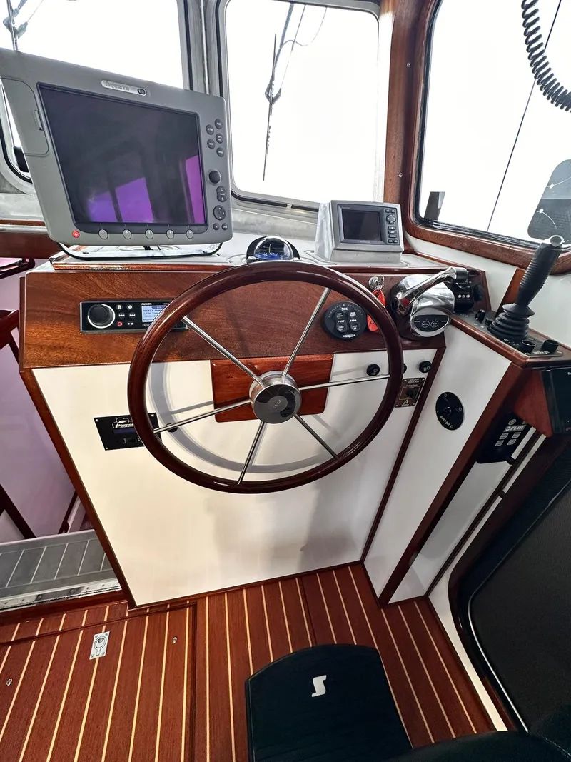 Slide: The Image of 2009 New England Boatworks Hunt 35 helm with wooden steering wheel and navigation equipment. - 11