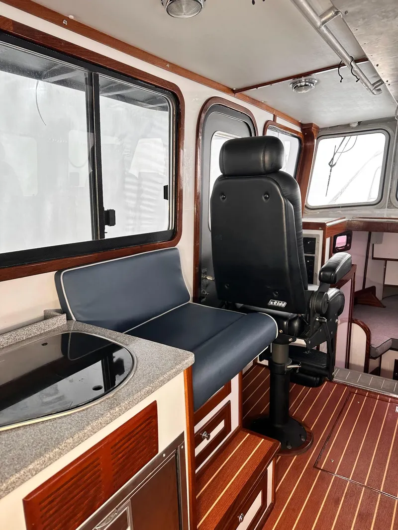 Slide: The Image of Interior of 2009 New England Boatworks Hunt 35, featuring seating and wood flooring. - 13