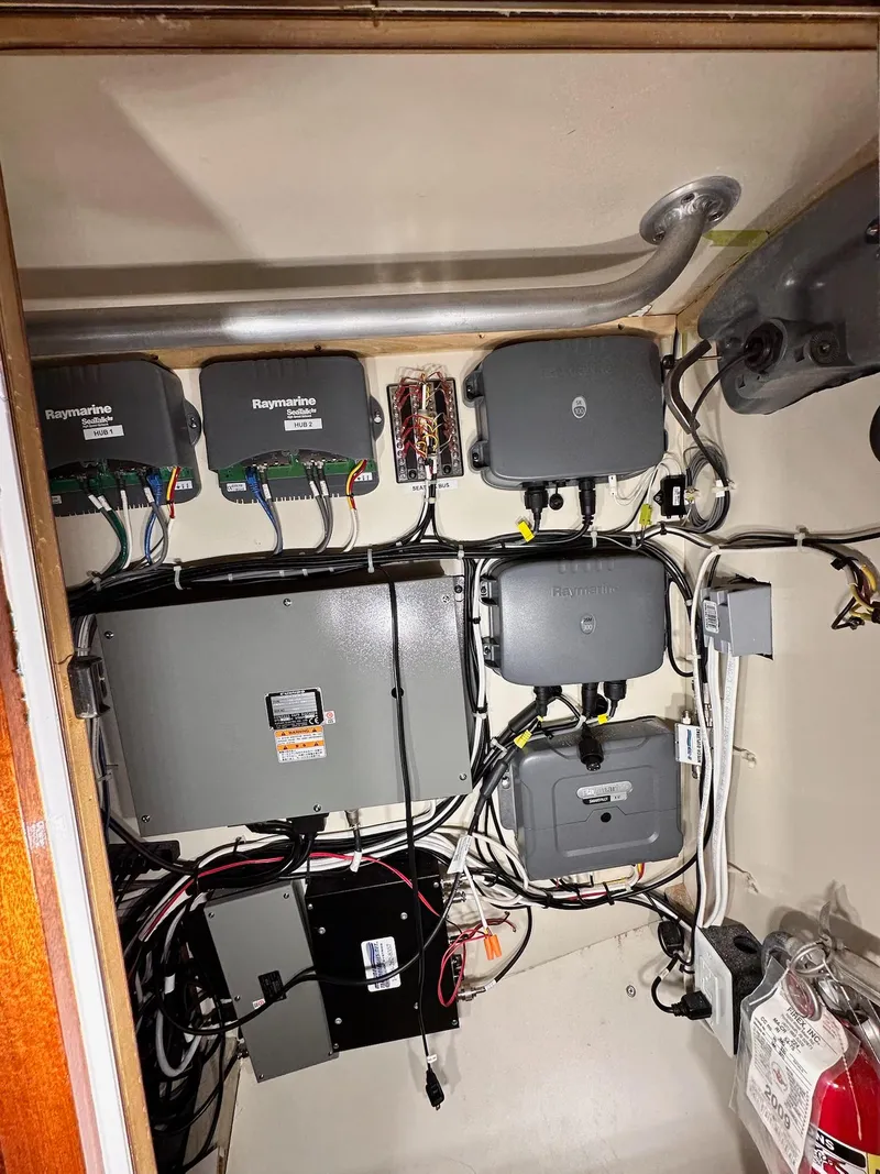 Slide: The Image of Electrical panel inside 2009 New England Boatworks Hunt 35, featuring Raymarine equipment and wiring. - 18