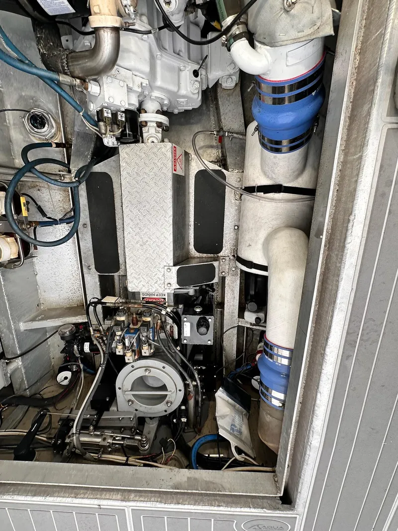 Slide: The Image of Engine compartment of 2009 New England Boatworks Hunt 35, showcasing mechanical components and piping. - 23