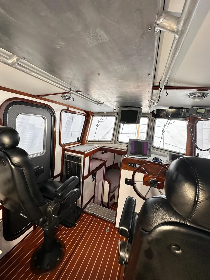 Slide: The Image of Interior of 2009 New England Boatworks Hunt 35, featuring helm, seating, and navigation equipment. - 5