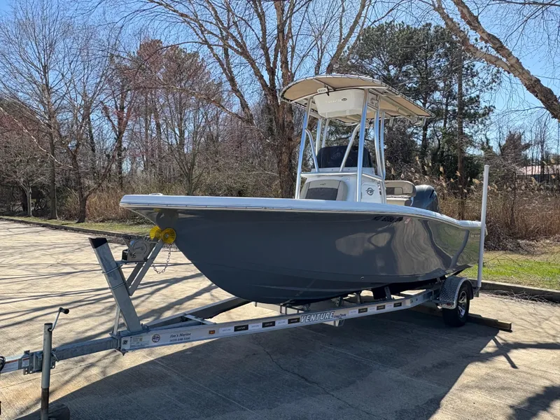 Slide: The Image of 2022 Tidewater 198 CC Adventure boat on trailer, parked outdoors. - 2