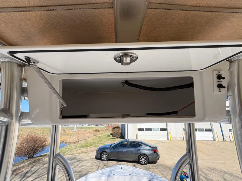 Slide: The Image of 2022 Tidewater 198 CC Adventure boat console with open storage compartment and control switches. - 23