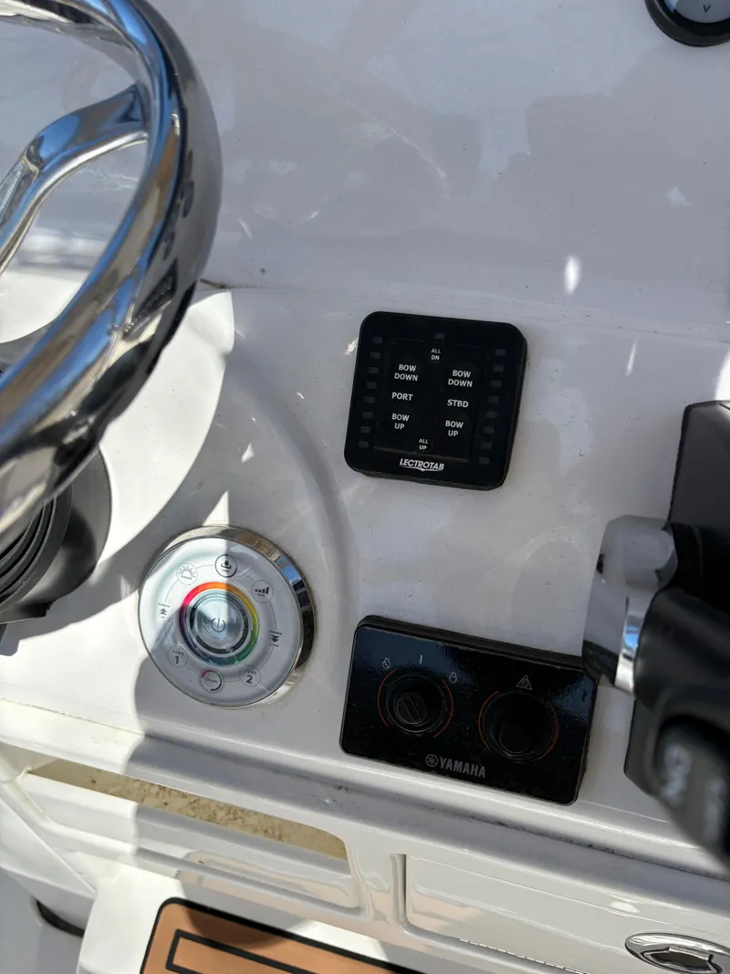 Slide: The Image of 2022 Tidewater 198 CC Adventure boat dashboard with steering wheel and control panel. - 27
