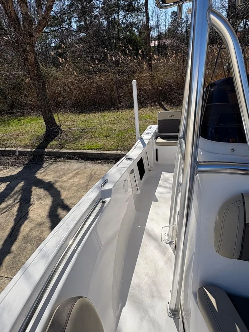 Slide: The Image of 2022 Tidewater 198 CC Adventure boat interior with seating and console, parked outdoors. - 31