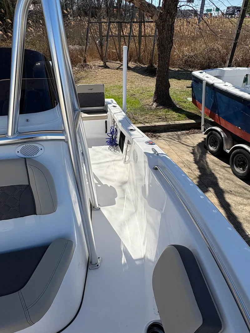 Slide: The Image of 2022 Tidewater 198 CC Adventure boat interior with seating and console, parked outdoors. - 32