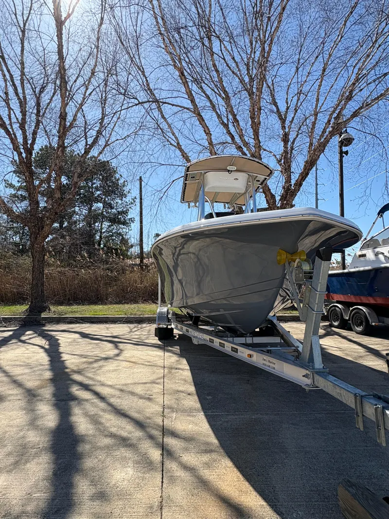 Slide: The Image of 2022 Tidewater 198 CC Adventure boat on trailer under clear blue sky. - 4