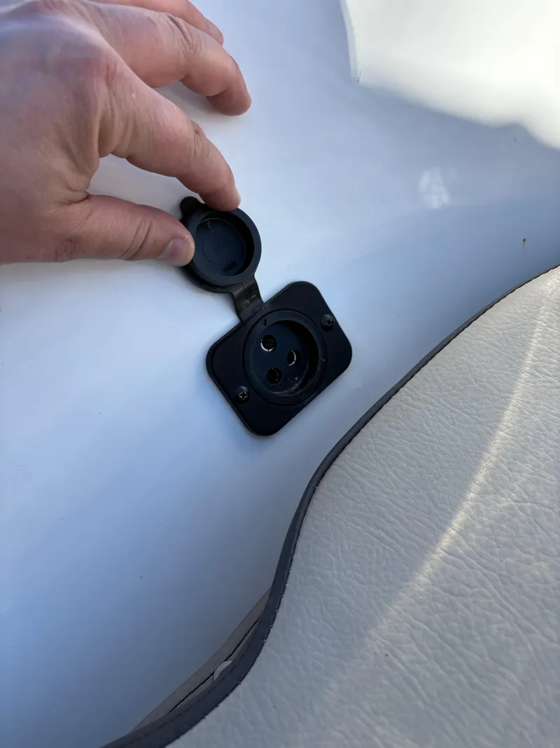Slide: The Image of Hand opening a socket cover on a 2022 Tidewater 198 CC Adventure boat. - 41