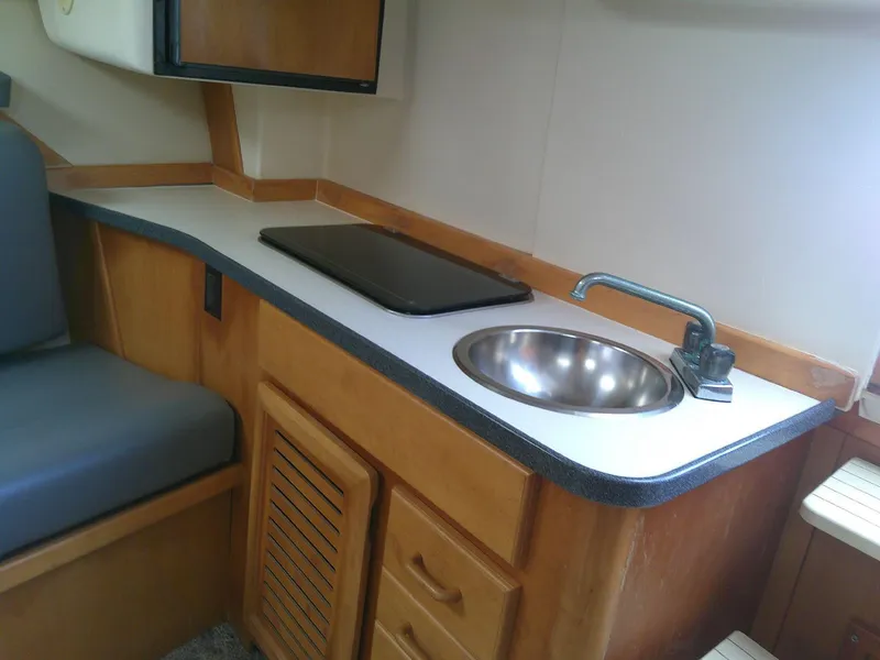 Slide: The Image of Compact kitchenette in 2000 Luhrs Tournament 290 Open boat, featuring sink and counter space. - 24