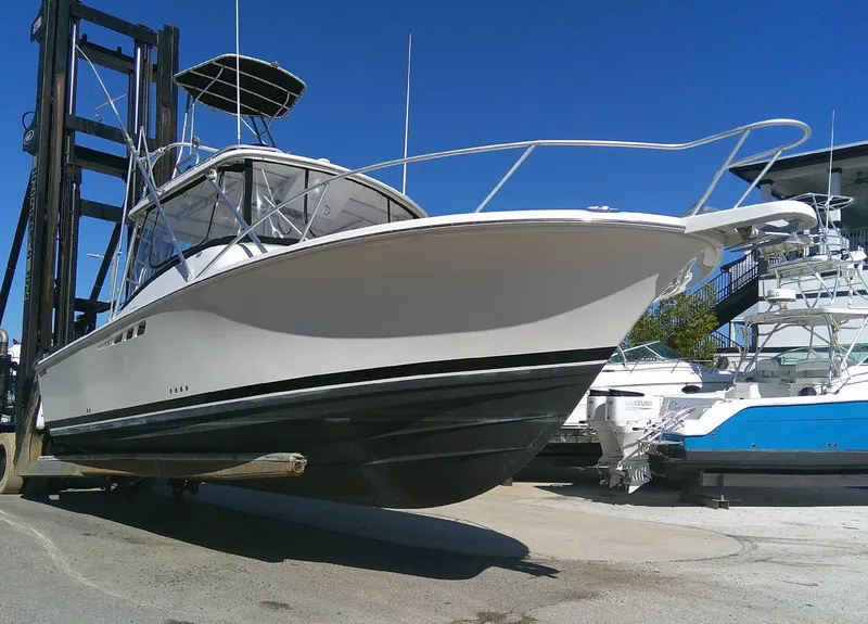 Slide: The Image of 2000 Luhrs Tournament 290 Open boat on forklift, white hull, marina background. - 5