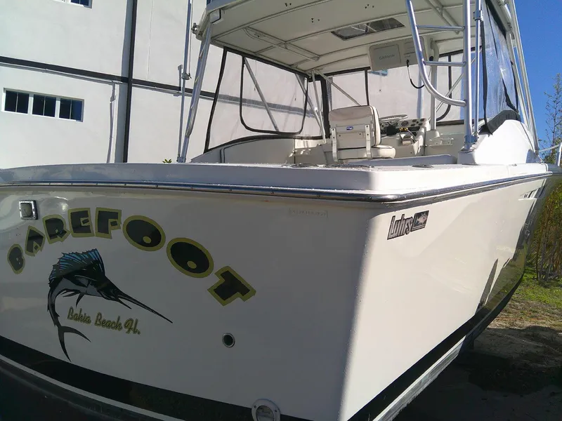 Slide: The Image of 2000 Luhrs Tournament 290 Open boat with "Barefoot" decal, docked outdoors. - 7