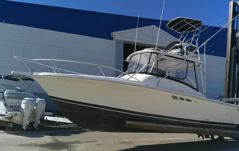Slide: The Image of 2000 Luhrs Tournament 290 Open boat on dry dock, white hull, blue building background. - 9