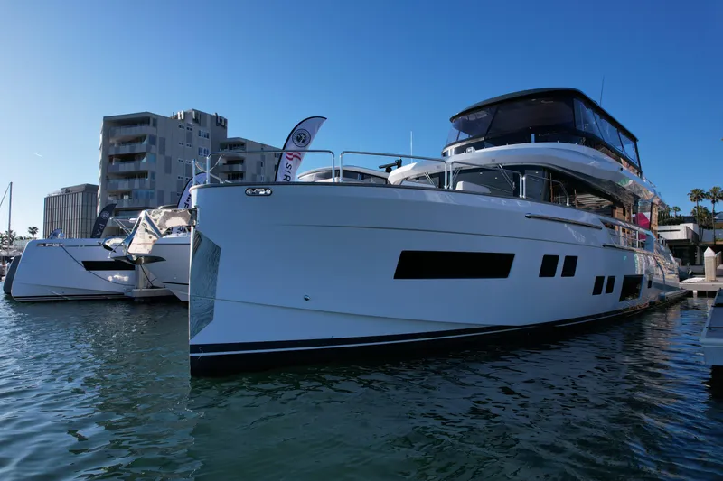 Slide: The Image of 2023 Sirena 68 yacht docked in marina, modern design, clear blue sky. - 5