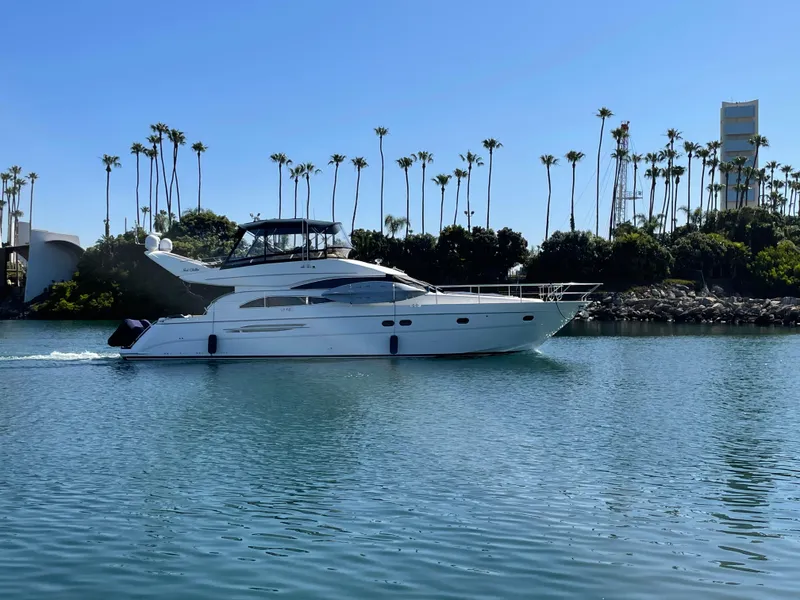 Slide: The Image of 2006 Viking Princess 61 Flybridge yacht cruising on calm water with palm trees in the background. - 1