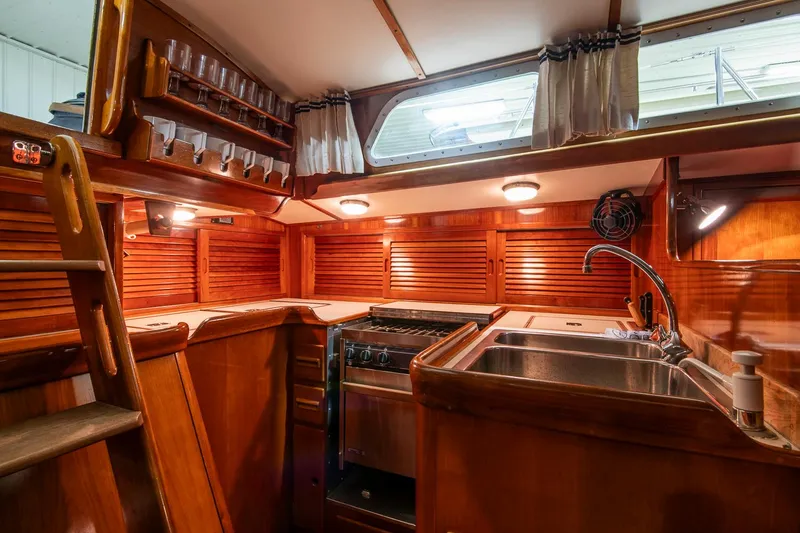 Slide: The Image of 1994 Hinckley Sou'wester 42 Sloop interior kitchen with wood finish, sink, and stove. - 21