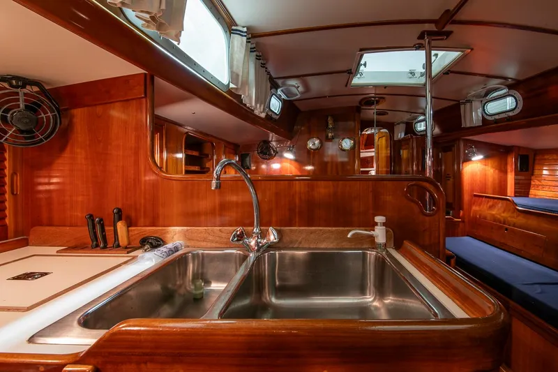 Slide: The Image of Interior of 1994 Hinckley Sou'wester 42 Sloop, featuring a wooden galley with a double sink. - 23
