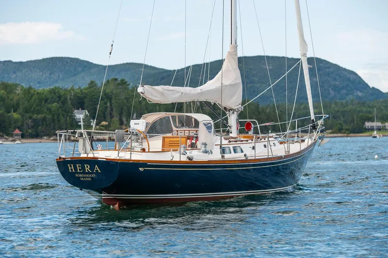 Slide: The Image of Hinckley Sou'wester 42 Sloop, 1994, sailing on calm waters with scenic mountain backdrop. - 7