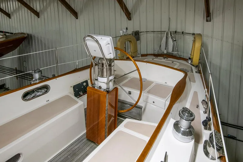 Slide: The Image of 1994 Hinckley Sou'wester 42 Sloop interior with wooden steering wheel in a storage facility. - 17