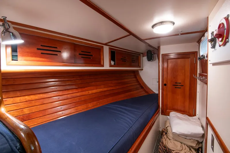 Slide: The Image of Hinckley Sou'wester 42 Sloop 1994 cabin interior with wooden finish and blue bedding. - 29