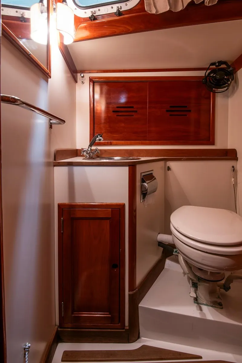 Slide: The Image of Hinckley Sou'wester 42 Sloop 1994 bathroom with wooden cabinetry and compact design. - 43