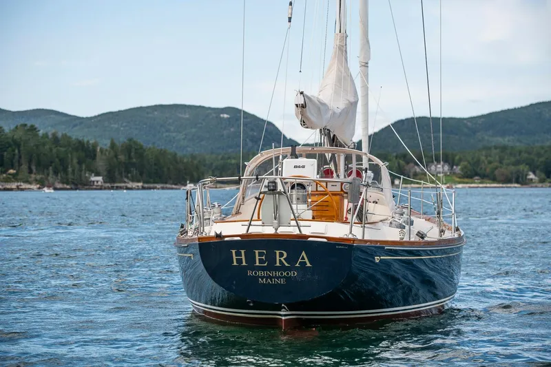 Slide: The Image of Hinckley Sou'wester 42 Sloop, 1994, sailing in scenic waters near forested hills. - 9