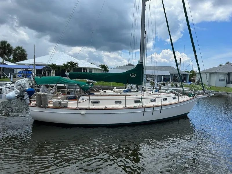 The Image of 1998 Island Packet 40 sailboat docked in a marina, under a cloudy sky. - 0
