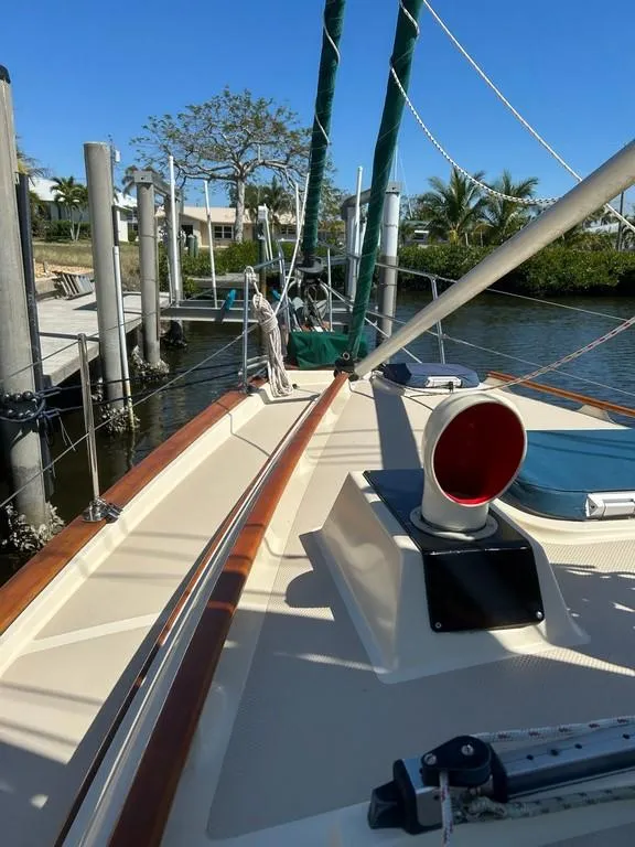 Slide: The Image of 1998 Island Packet 40 sailboat docked, showcasing deck and rigging under clear blue sky. - 10