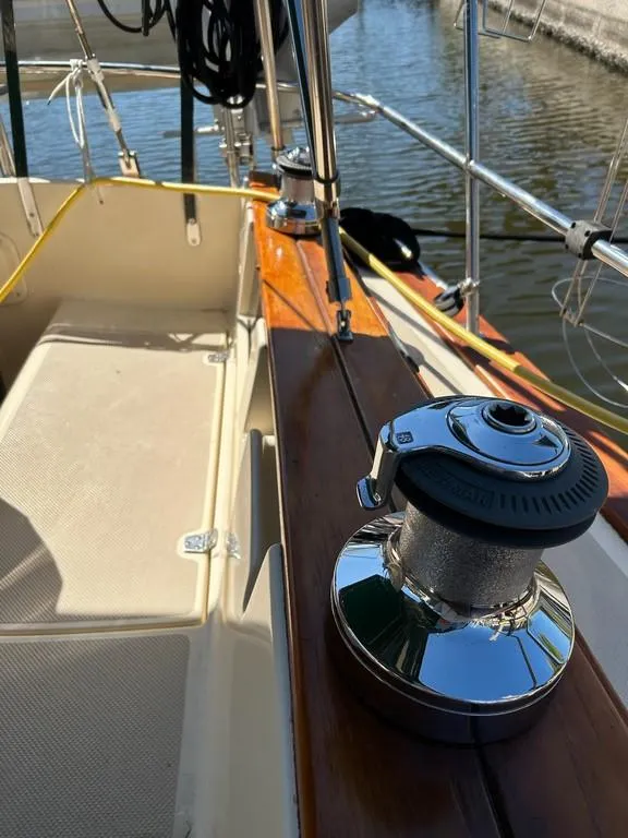 Slide: The Image of 1998 Island Packet 40 sailboat deck with winch, docked by the water. - 23