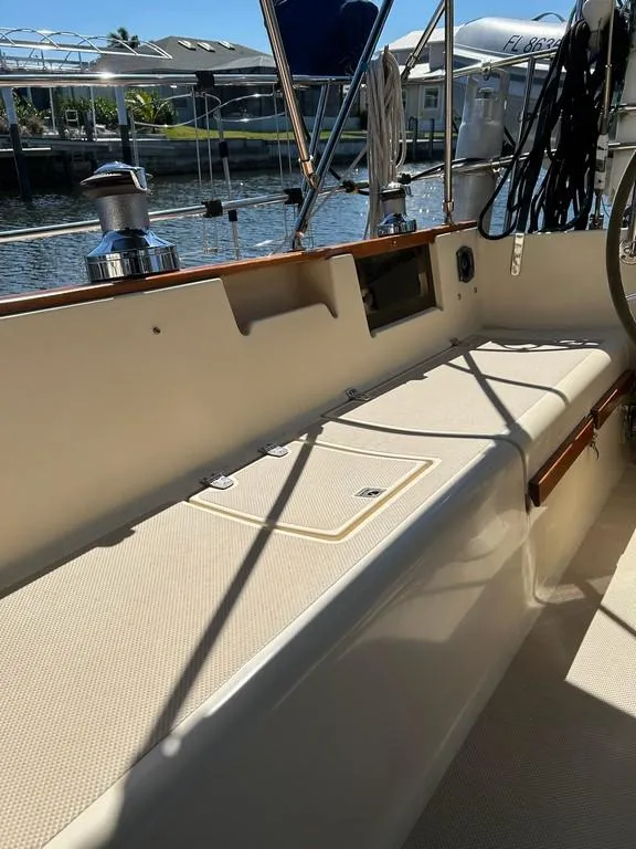 Slide: The Image of 1998 Island Packet 40 sailboat cockpit with seating and winches, docked by the water. - 38
