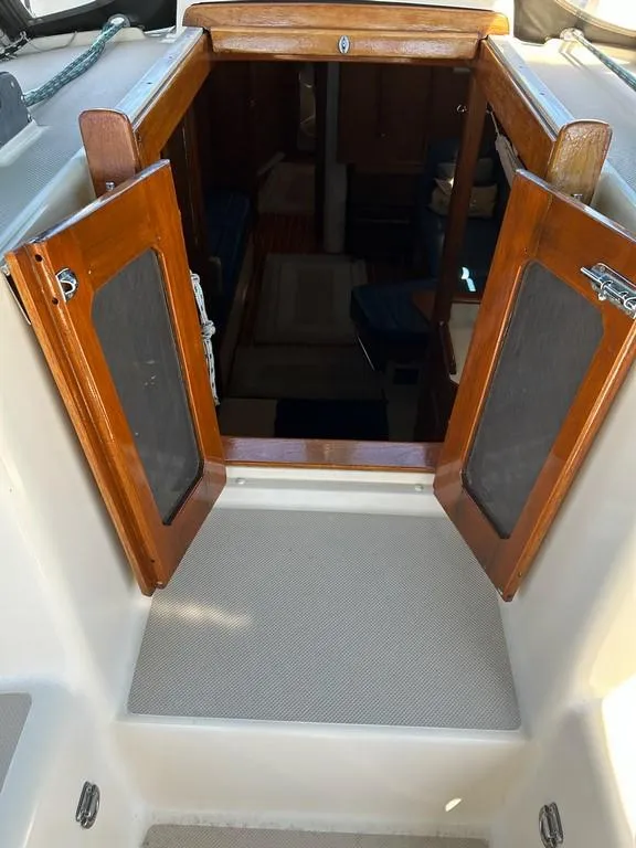Slide: The Image of 1998 Island Packet 40 sailboat cabin entrance with wooden doors and interior view. - 40