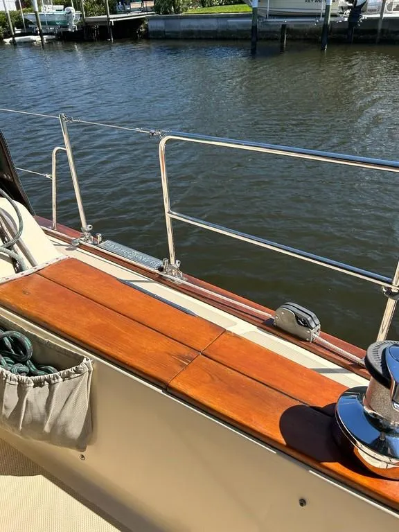 Slide: The Image of 1998 Island Packet 40 sailboat deck with wooden seating and railing by the water. - 41