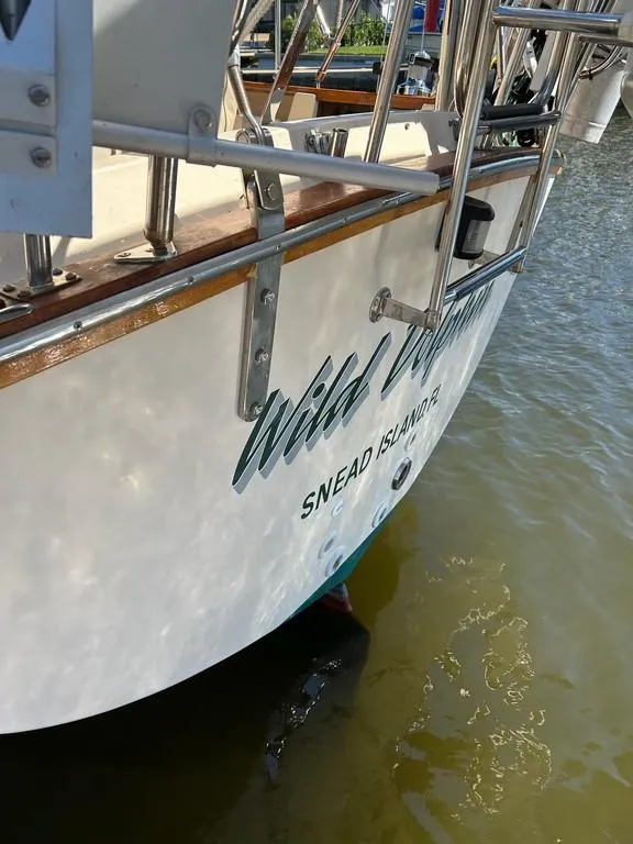 Slide: The Image of 1998 Island Packet 40 sailboat docked, featuring "Wild" name and Snead Island location. - 48