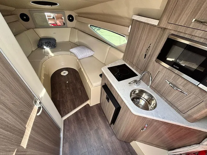 Slide: The Image of Interior of 2020 Regal 28 Express boat with kitchenette and seating area. - 6