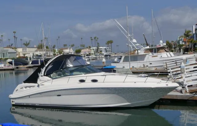 The Image of 2005 Sea Ray 340 Sundancer yacht docked in a marina, surrounded by other boats. - 1
