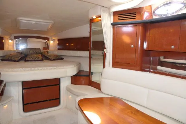 Slide: The Image of 2005 Sea Ray 340 Sundancer cabin interior with wood finishes and cozy seating area. - 10