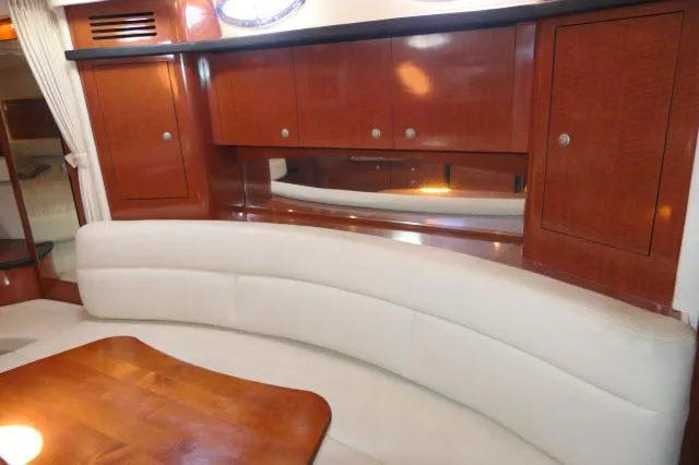 Slide: The Image of Interior of 2005 Sea Ray 340 Sundancer with curved seating and wooden cabinetry. - 11