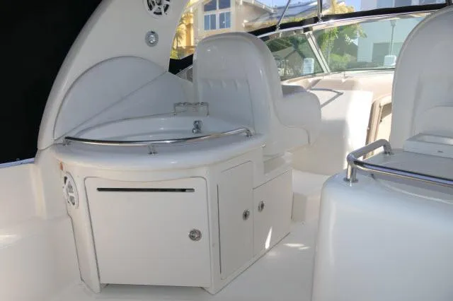 Slide: The Image of 2005 Sea Ray 340 Sundancer interior with white seating and compact kitchenette. - 28